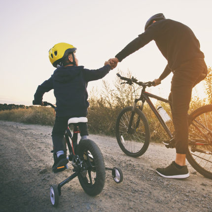 Barn och son cyklar tillsammans